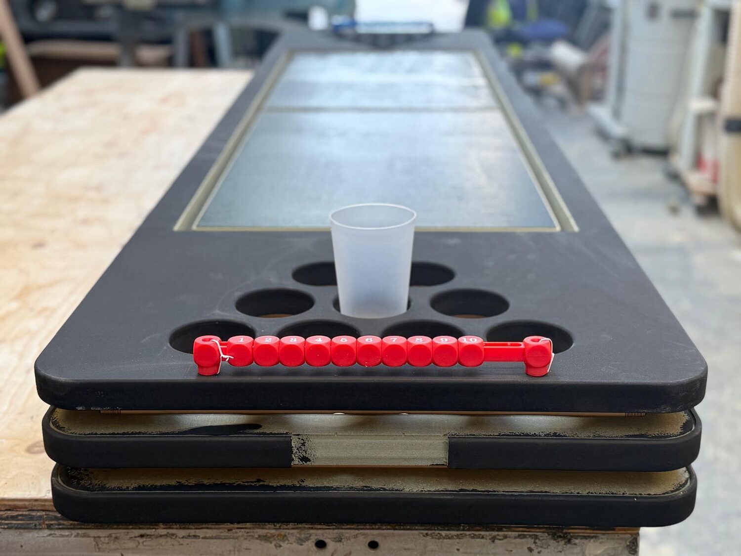 Close-up of a cup sitting in its well above the row of circular LED PCBs on the bare tabletop.